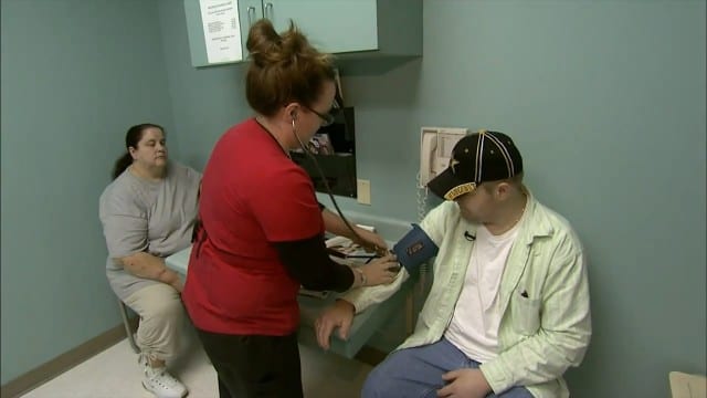 Man having blood pressure taken while woman looks on