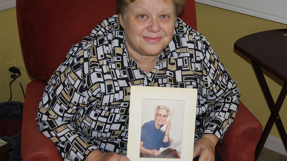 Judy Bellome, of Lawrence, helped cared for her diabetic mother until her death. Bellome is now among those supporting a bill to require more instruction for caregivers before patients are discharged from the hospital. She's holding a picture of her mother, Eleanor Francis. (Photo by Andy Marso/KHI News Service)