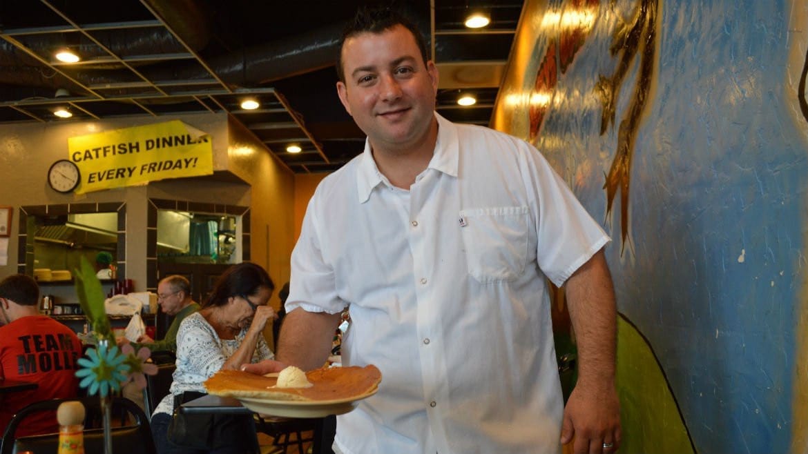 Nick de Feo, Jr.grabs a pancake during the morning breakfast rush. The pancakes are so big that if you took them for carry out, 