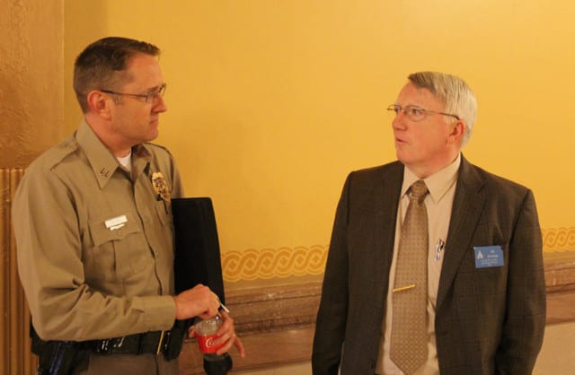 Wichita police officer Brian White, left, talks with Ed Klumpp, a lobbyist for several law enforcement organizations, after the two testified at a hearing on the Kansas foster care system. (Andy Marso | Heartland Health Monitor)