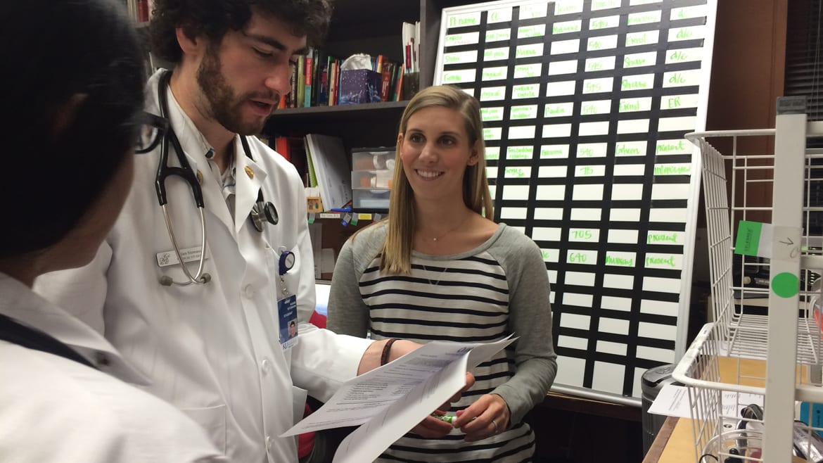 KU Med student Maddy Breedan (right) talks about patient treatment with fellow student Adam Stizmann at the JayDoc Free Clinic. Med students must weigh income, patient needs when choosing a future path. (Photo: Alex Smith | Heartland Health Monitor)