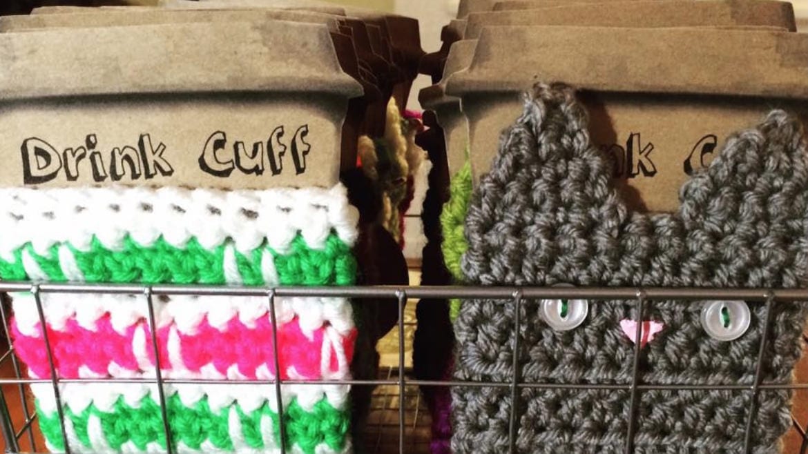 Knitted koozies, one in the shape of a cat.