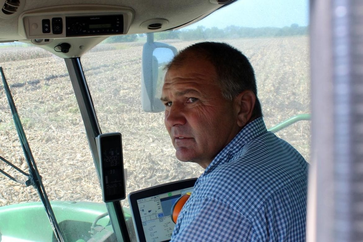 A man driving farm equipment through a field.