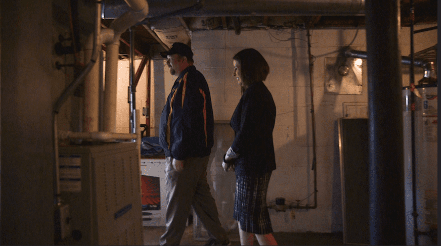A man and woman walking in a basement