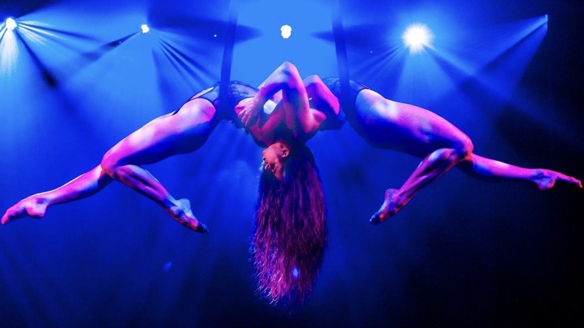 Two Quixotic performers dangle above the stage in pose.