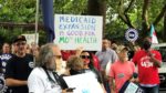 Demonstrators stand outside of the Governor's Mansion in Jefferson City on July 1, 2021 and hold signs urging Gov. Mike Parson to fund voter-approved Medicaid expansion.