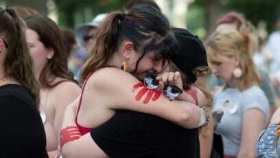 19-year-old Topekan Chole Easley, left, hugs her friends during a rally at the Statehouse Friday, June 24, 2022 in Topeka, Kansas.