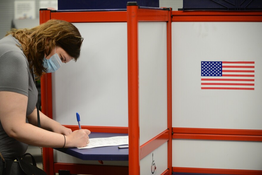 Women in voting a booth.