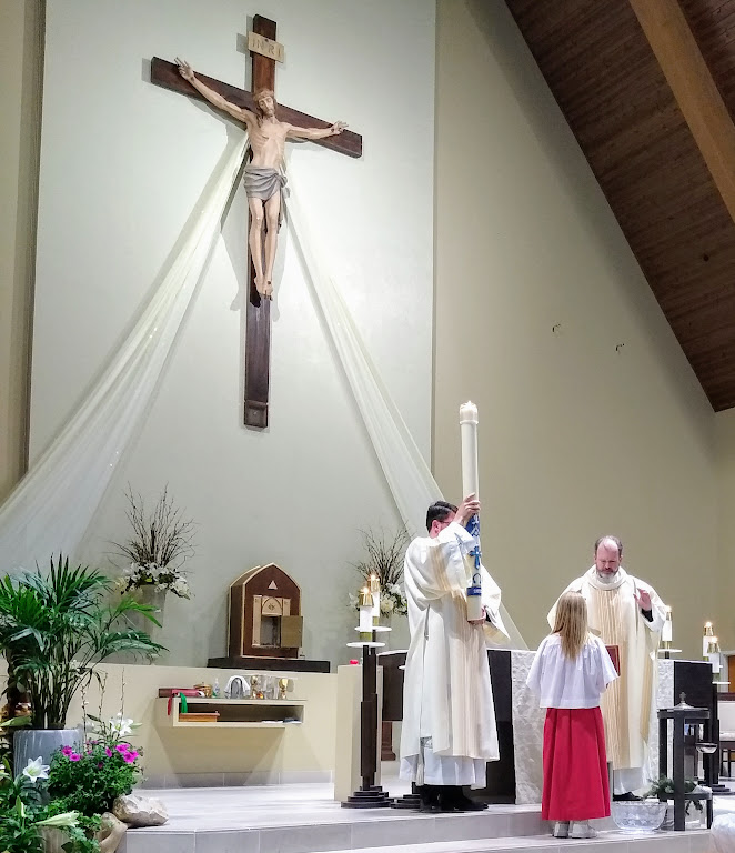 Fr. Justin Hoye reads scripture at a Sunday morning worship service at St. Thomas More Catholic Church.