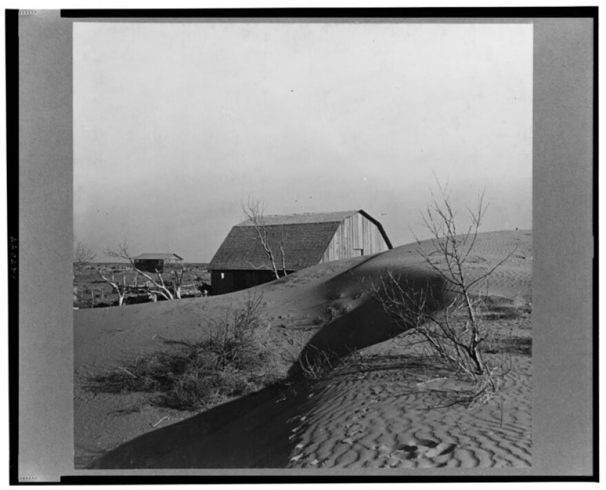 This photo from 1936 shows how Dust Bowl winds piled up large drifts of dry soil against a farmer's barn near Liberal in southwest Kansas.