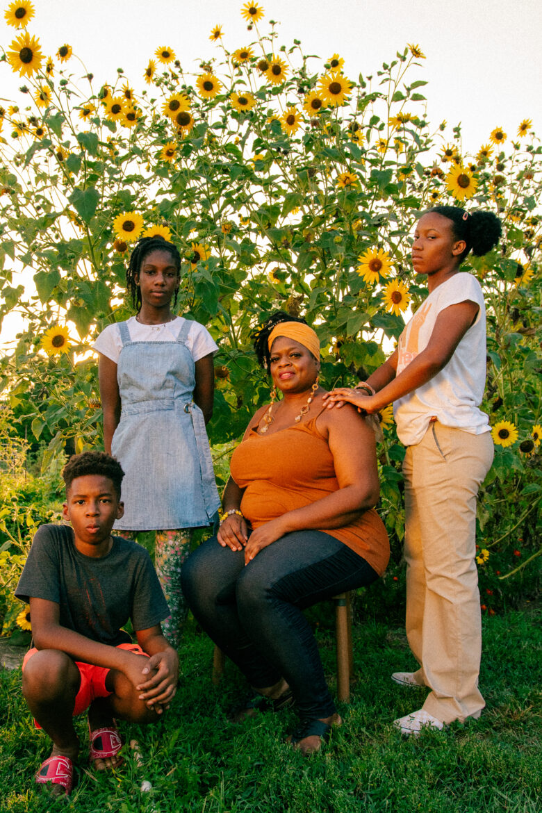 August's garden therapy crew stands against a backdrop of sunflowers. (Clockwise from left) Riyad Ba, 11, Zara Ba, 13, Denise Perkins at center and Liberty Williams, 13, before class began. (Ji Stribling | Flatland))