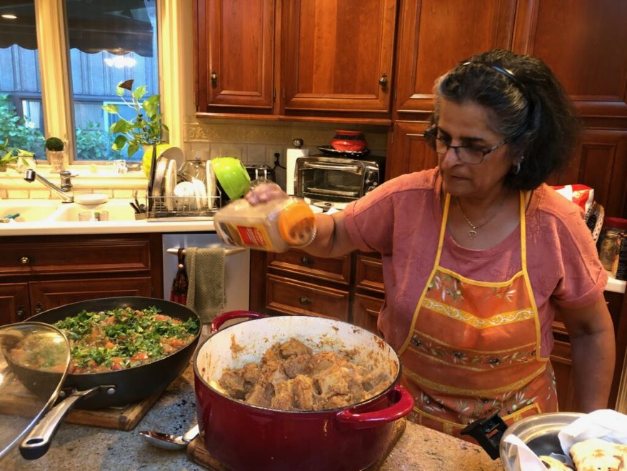 Jyoti Mukharji seasons a jackfruit korma as students prepare to eat the meal she has demonstrated for her students on a recent Sunday afternoon.