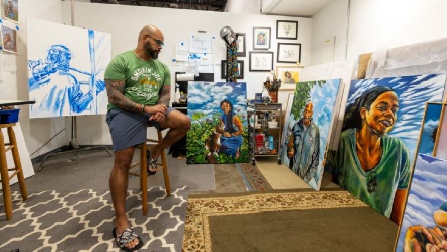 Kwanza Humphrey in his studio at the InterUrban ArtHouse in Overland Park, with four paintings that are part of his commission for the new KCI terminal. Pictured (far left to right) are “Jose,” “In the Garden,” “Harold’s Canvases” and “Jana Sky.”
