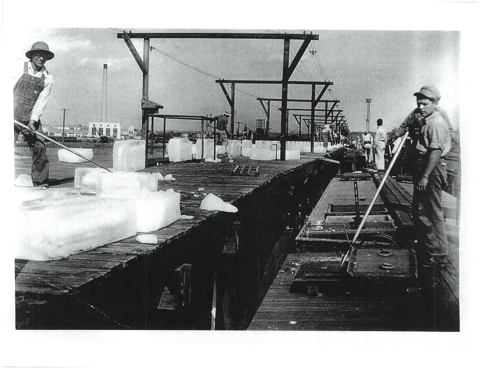A worker pushes ice across the dock. (Quiroga Family)