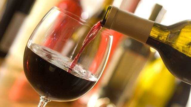 A glass of red wine being poured.