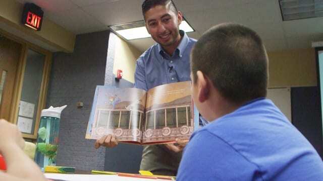 Man showing book to child.