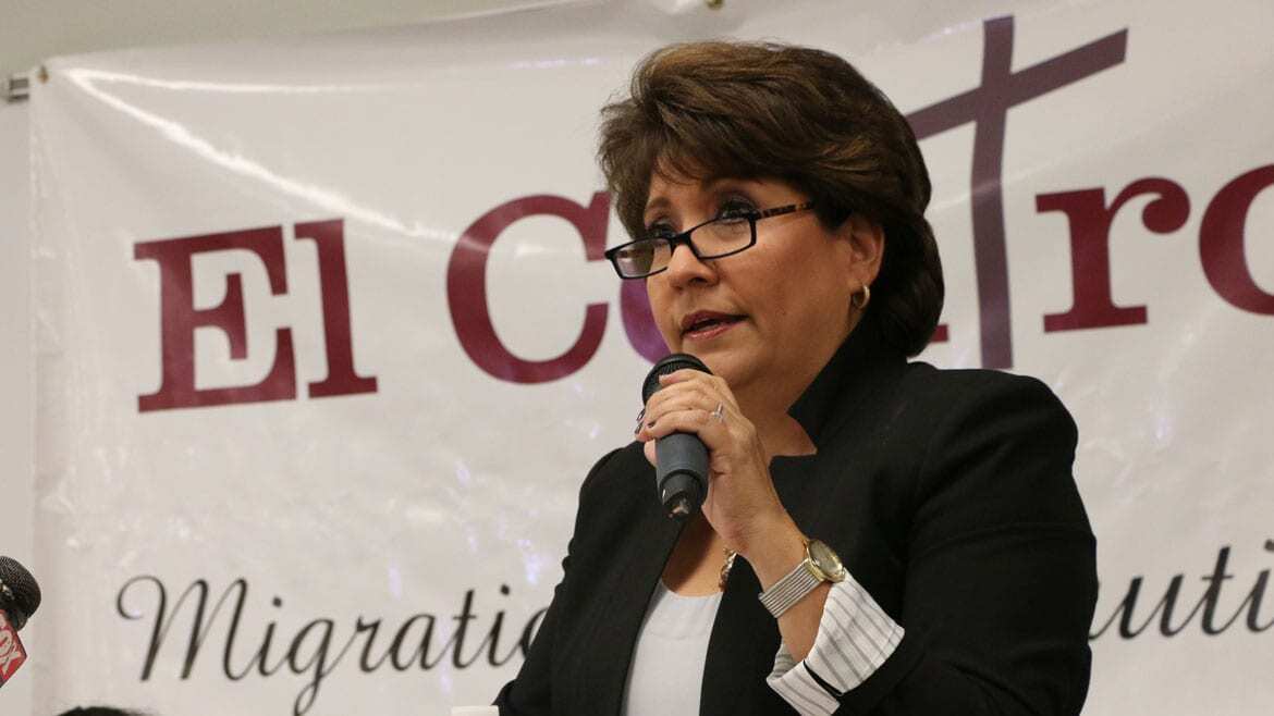 Latina woman speaks at a podium