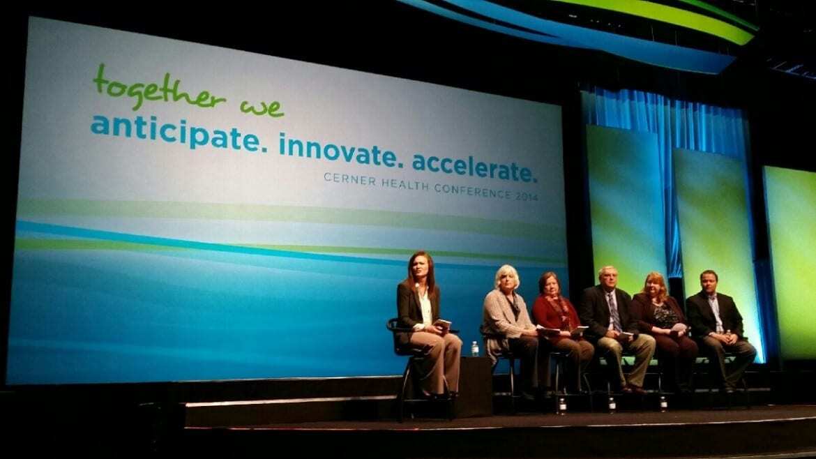 Photo of 6 panelists on stage with Cerner Health Conference logo on large screen