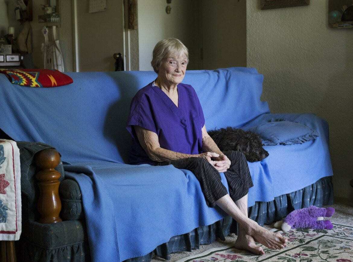 Patricia Corry sitting on her sofa