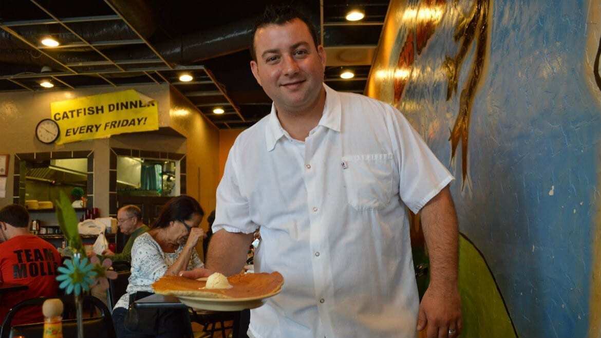 Nick de Feo, Jr.grabs a pancake during the morning breakfast rush. The pancakes are so big that if you took them for carry out, "we’ve got to put it in a pizza box," he says. (Photo: Jonathan Bender | The Recommended Daily)