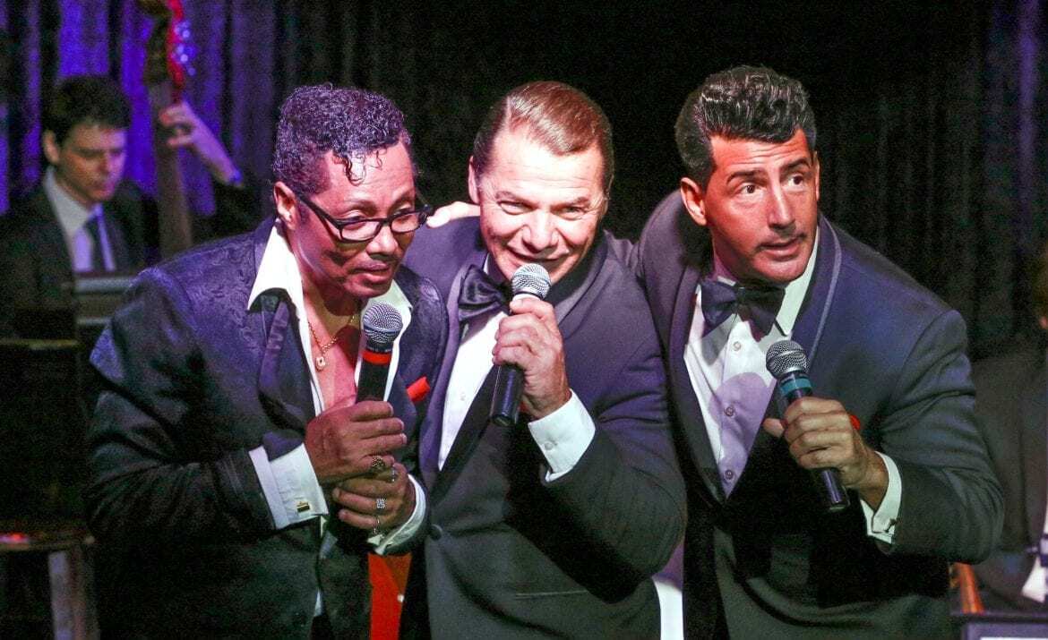 Three men singing on stage.