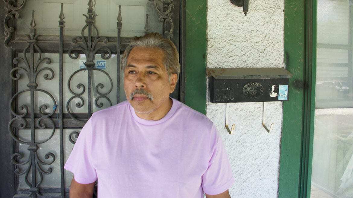 Tom Ribera stands in front of a house he is rehabbing