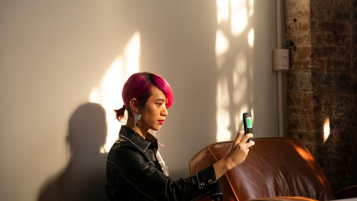 A non-binary femme using their phone