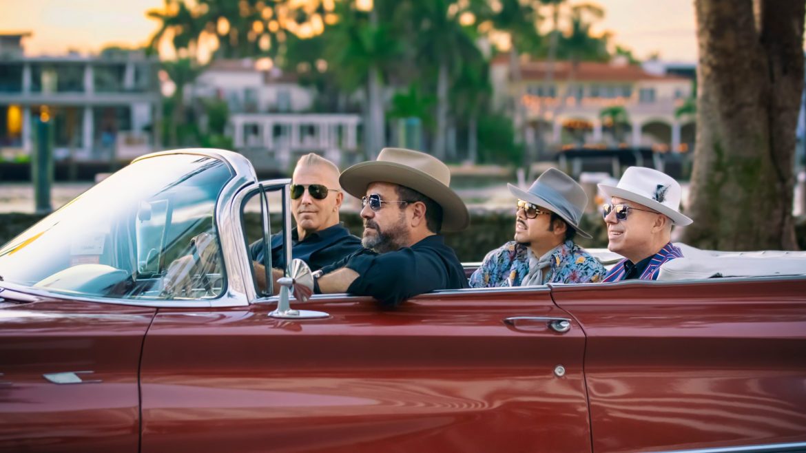 The Mavericks band rides in a convertible.