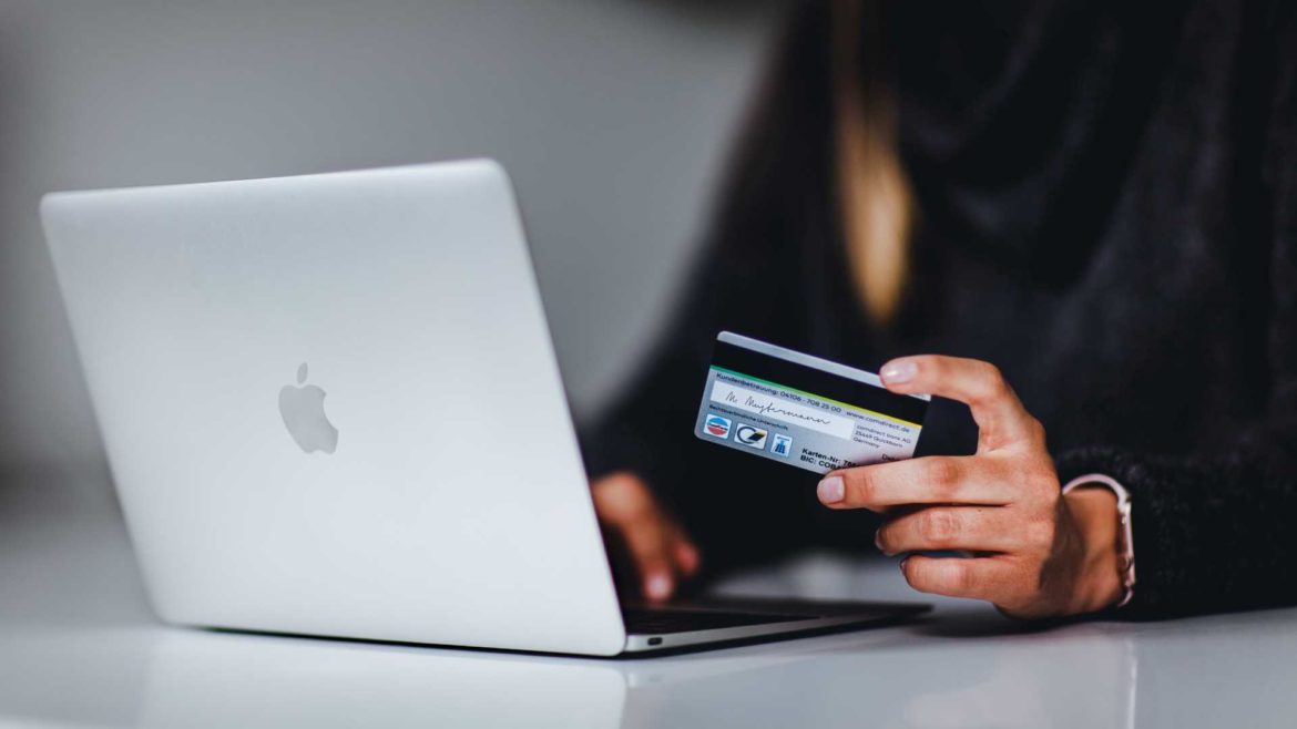 A person entering credit card information via a laptop computer.