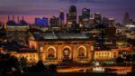 Union Station at night with the downtown skyline in the background.