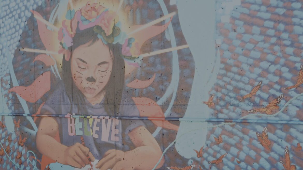 Section of mural with girl in Believe shirt