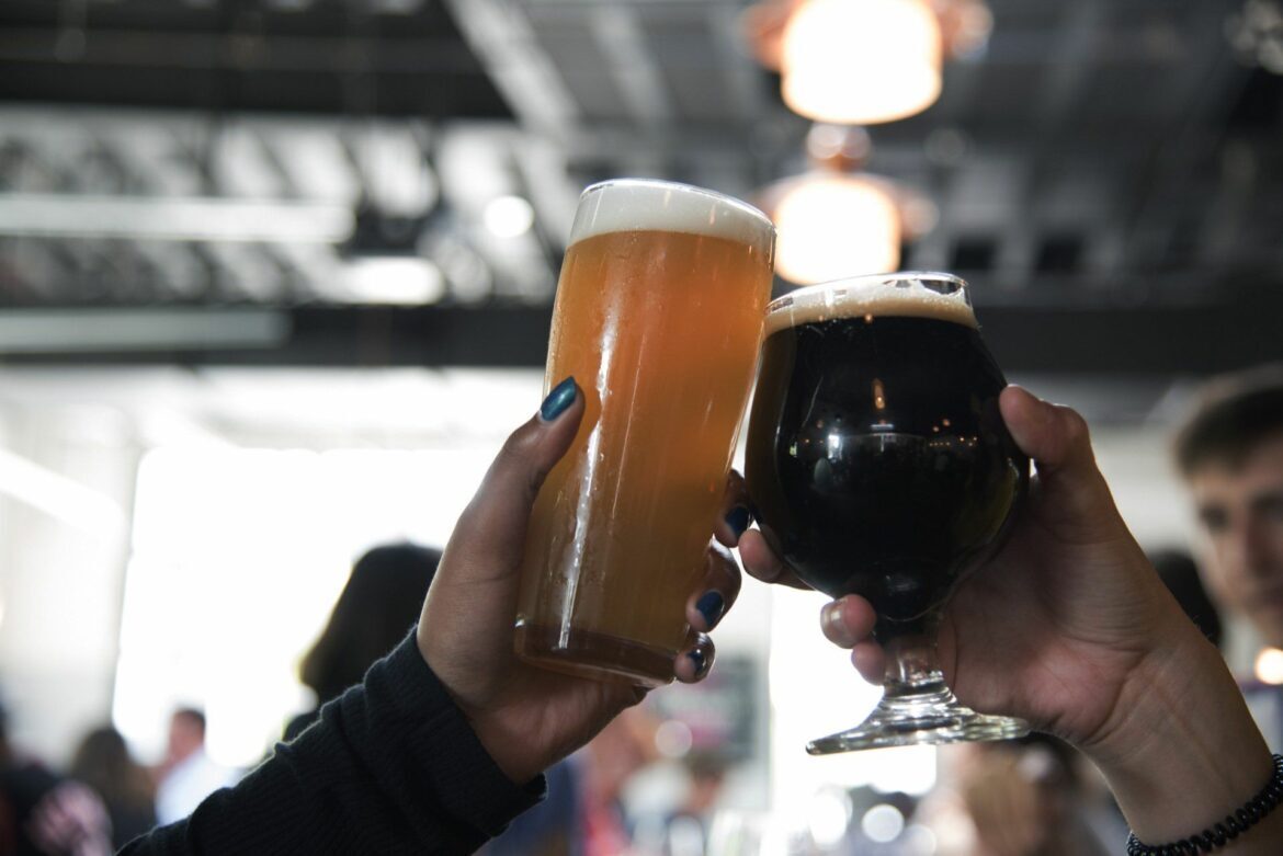 People toasting two beers.