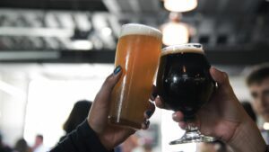 People toasting two beers.