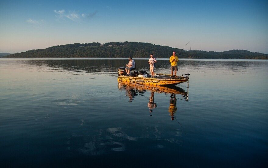Three people fishing in a boat on Table Rock Lake.