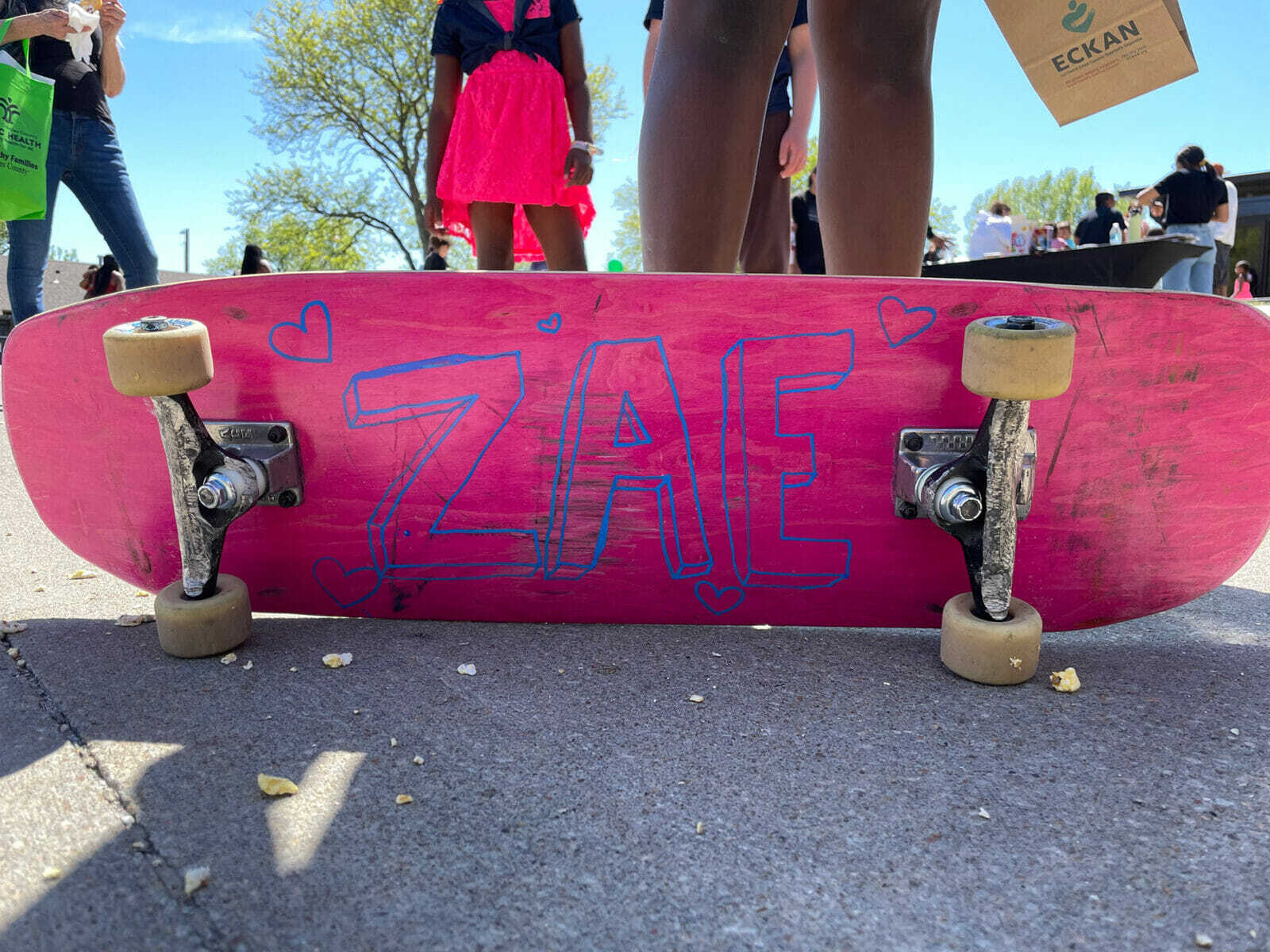 A pink skateboard with the letters "ZAE" painted on. In Lawrence, Kansas local community and skate leaders compiled their gently used extra parts to give kids who live in low-income housing a chance at skate culture.