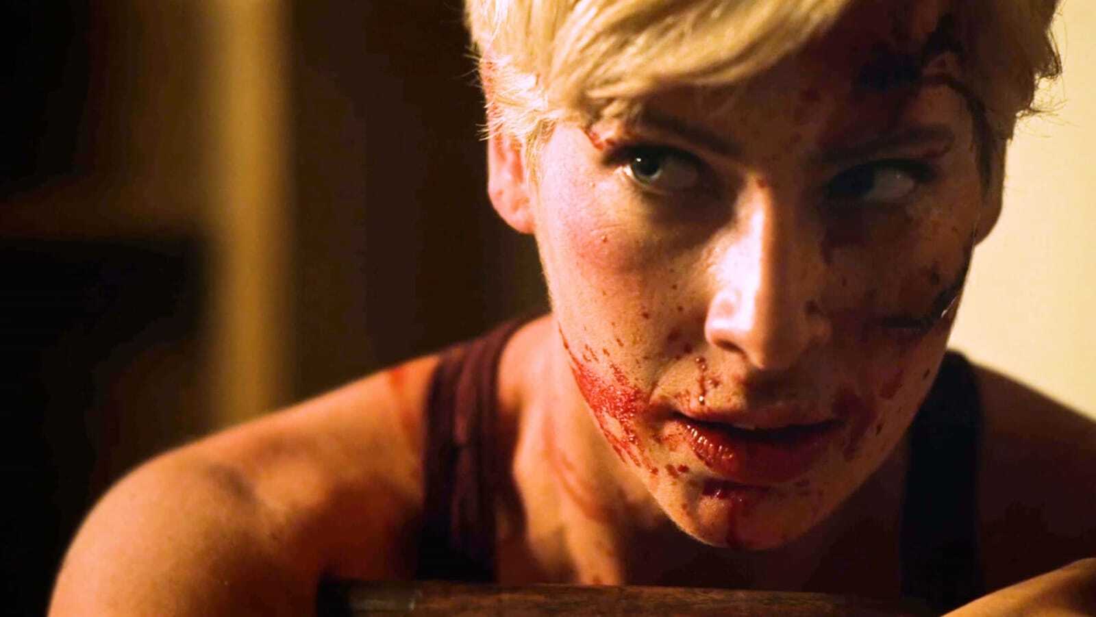 A scene from Patrick Rea's "They Wait in the Dark" shows a woman's blood-spattered face.