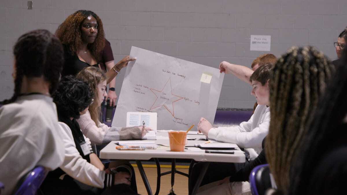 Students hold up a poster with a star in the middle and notes written all around it.