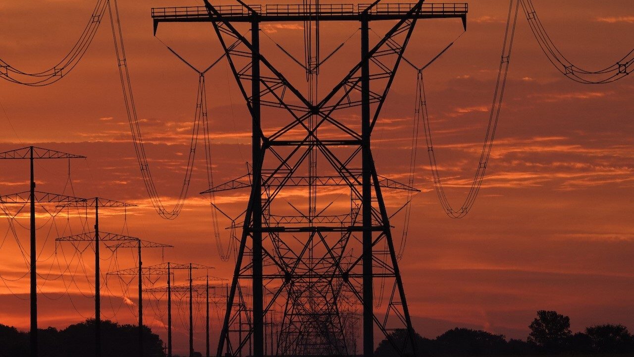 Power lines with a red sunset in the background.