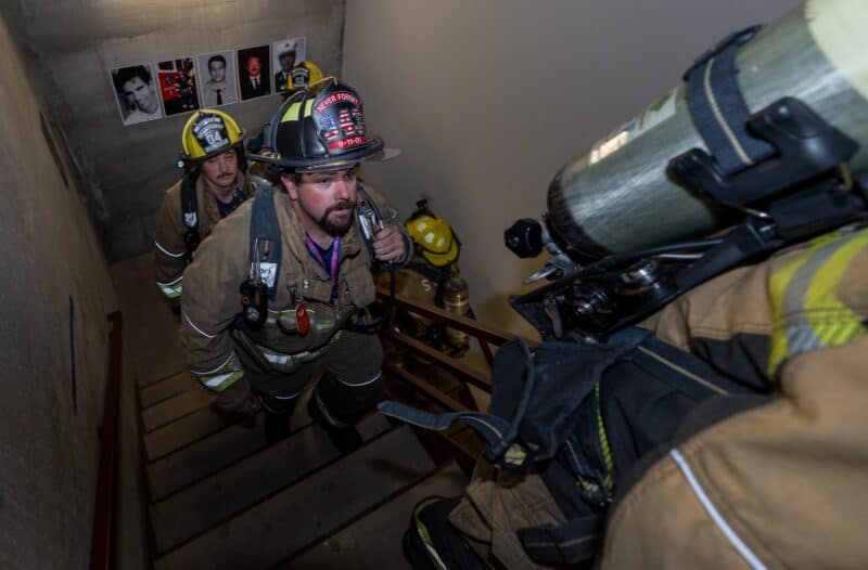 Robert Ohlsen from the Seneca, Kansas Fire Department, climbs another flight of stairs on Sept. 6, 2026, in honor of the 343 firefighters that lost their lives 25 years ago when the Twin Towers collapsed. The participating firefighters climbed 110 stories to represent the height of the Twin Towers. Posted on each landing are photos of firefighters killed in the aftermath of the terrorist attack. (Todd Feeback | Flatland)