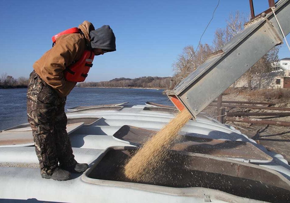 An MFA Agriservices worker monitors the soybean chute as the barge fills up on the Missouri River in Glasgow, Mo. (Kristofor Husted/Harvest Public Media)
