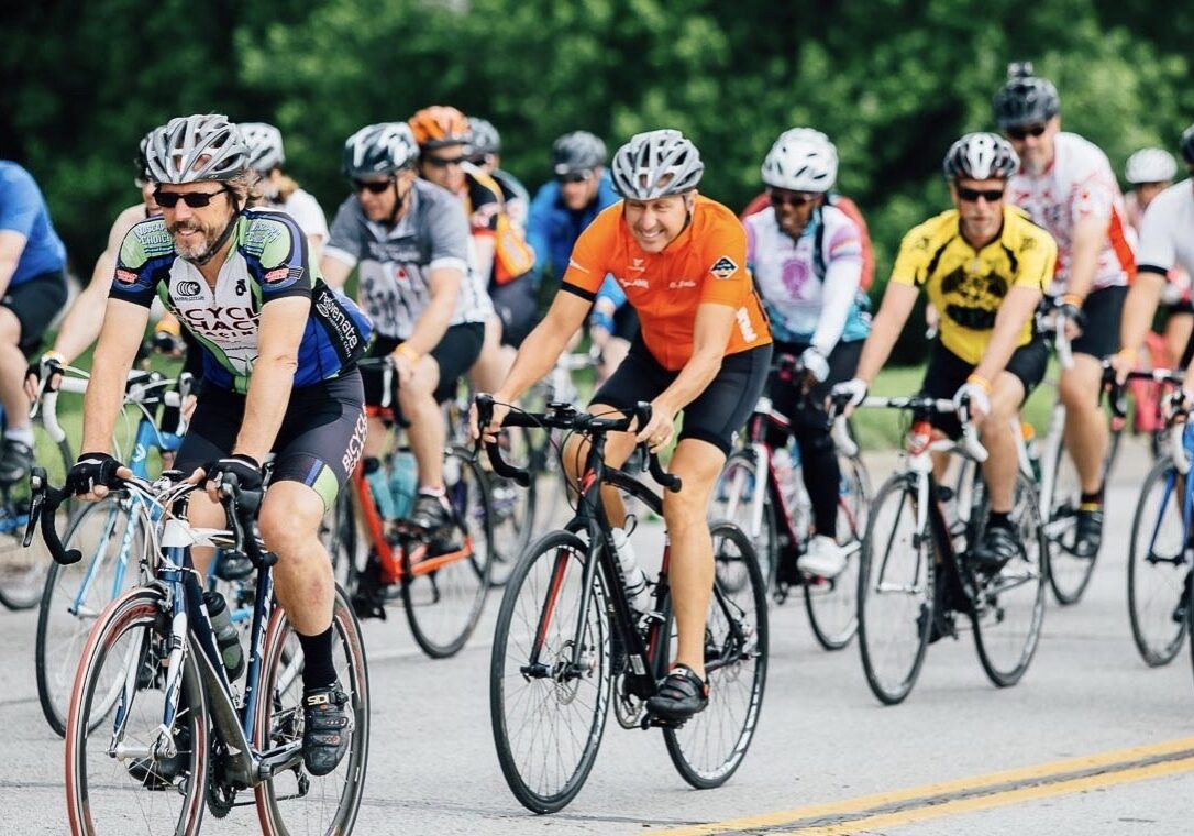 A group of cyclists ride in a pack.