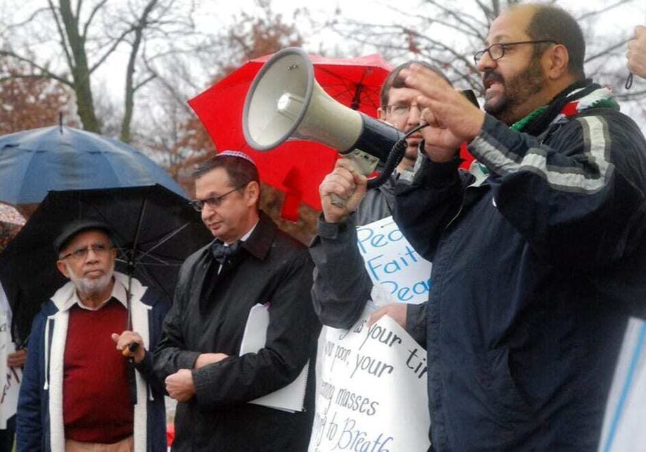Syrian immigrant Fadi Banyalmarjeh speaks during a rally hosted by "People of Faith for Peace," while to his left group member Ken Sonnenschein and Rabbi Douglas Alpert look on. Banyalmarjeh, who came to Kansas City via Kuwait, stressed to the crowd the difficulty for refugees to meet the government's requirements. For more from him, click play above.  (Photos and audio by Steve Mencher | Flatland)