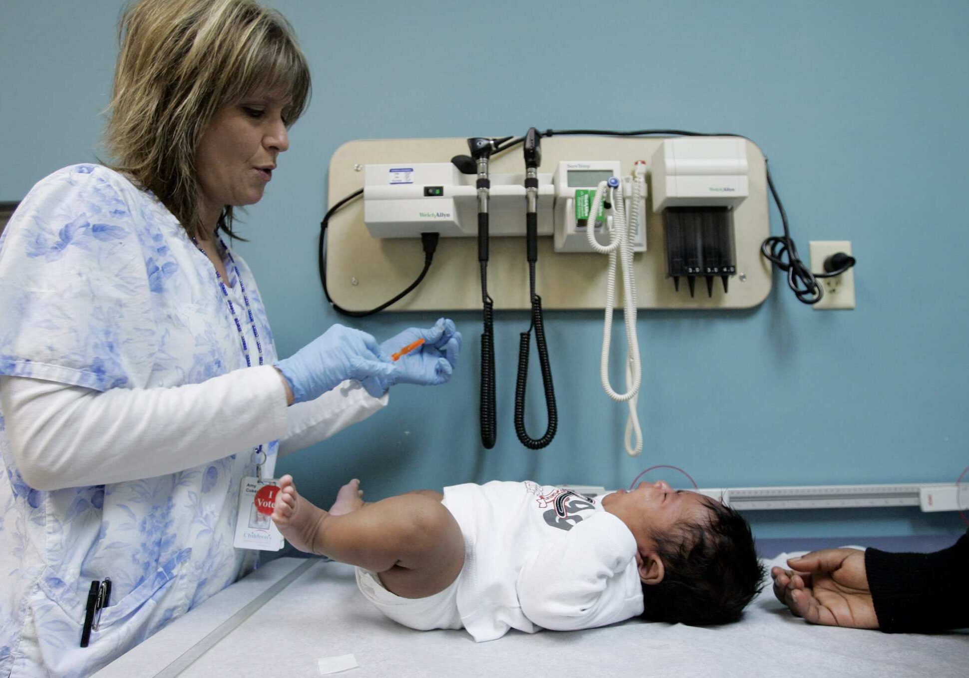 ** ADVANCE FOR DEC. 26 ** Medical assistant Amy Coker, left, prepares a vaccination for two-month-old Andre Gordon, Jr., during a wellness check at Children's Hospital in Minneapolis, Monday, Dec. 18, 2006. Health coverage for all Minnesota kids will be a top priority in the upcoming legislative session. As Children's Hospital sees more kids than any other hospital or clinic in the state, it will be impacted no matter what the legislature decides to do with health coverage for children.(AP Photo/Ann Heisenfelt)