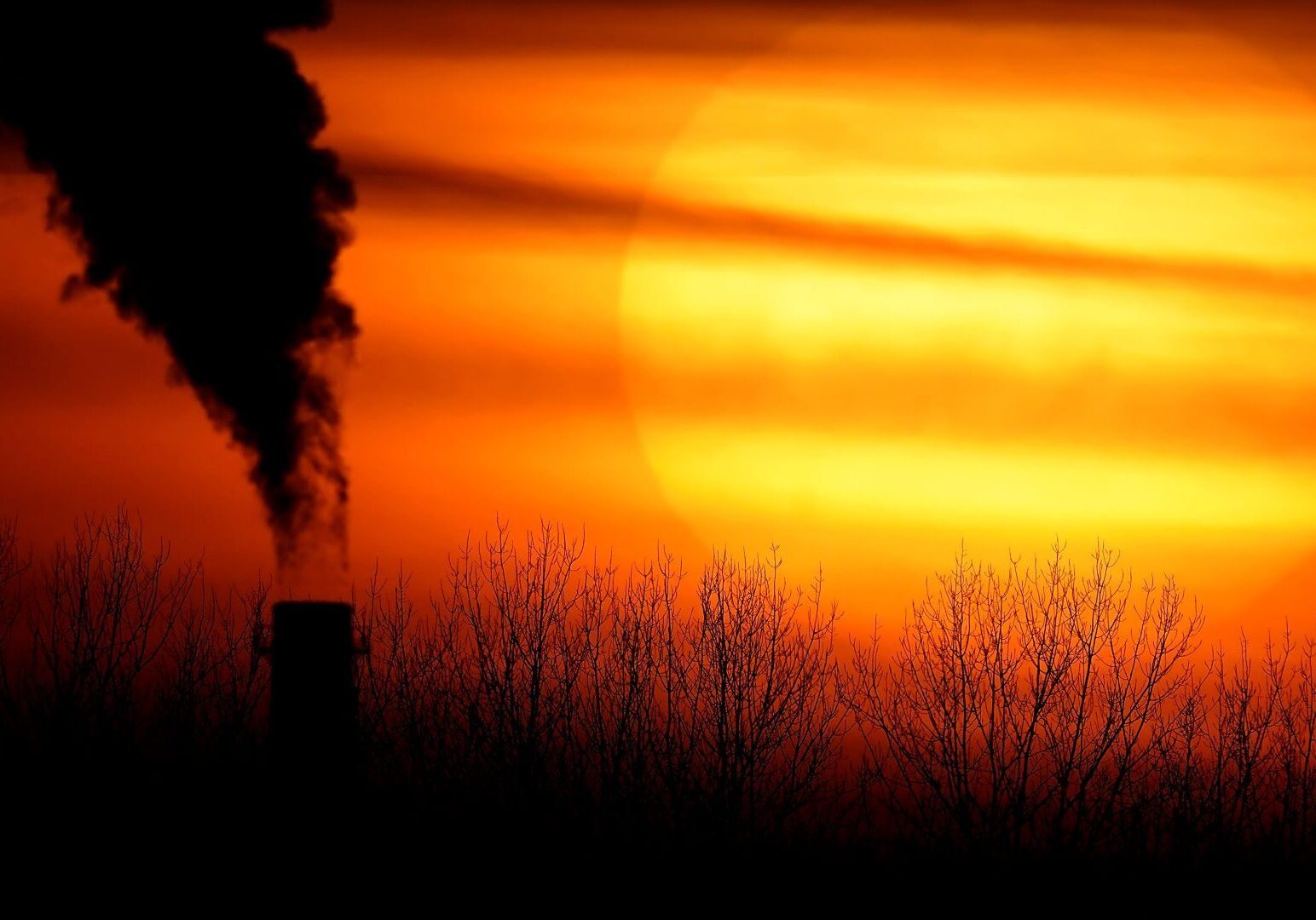 In this Feb. 1, 2021 file photo, emissions from a coal-fired power plant are silhouetted against the setting sun in Kansas City, Missouri.