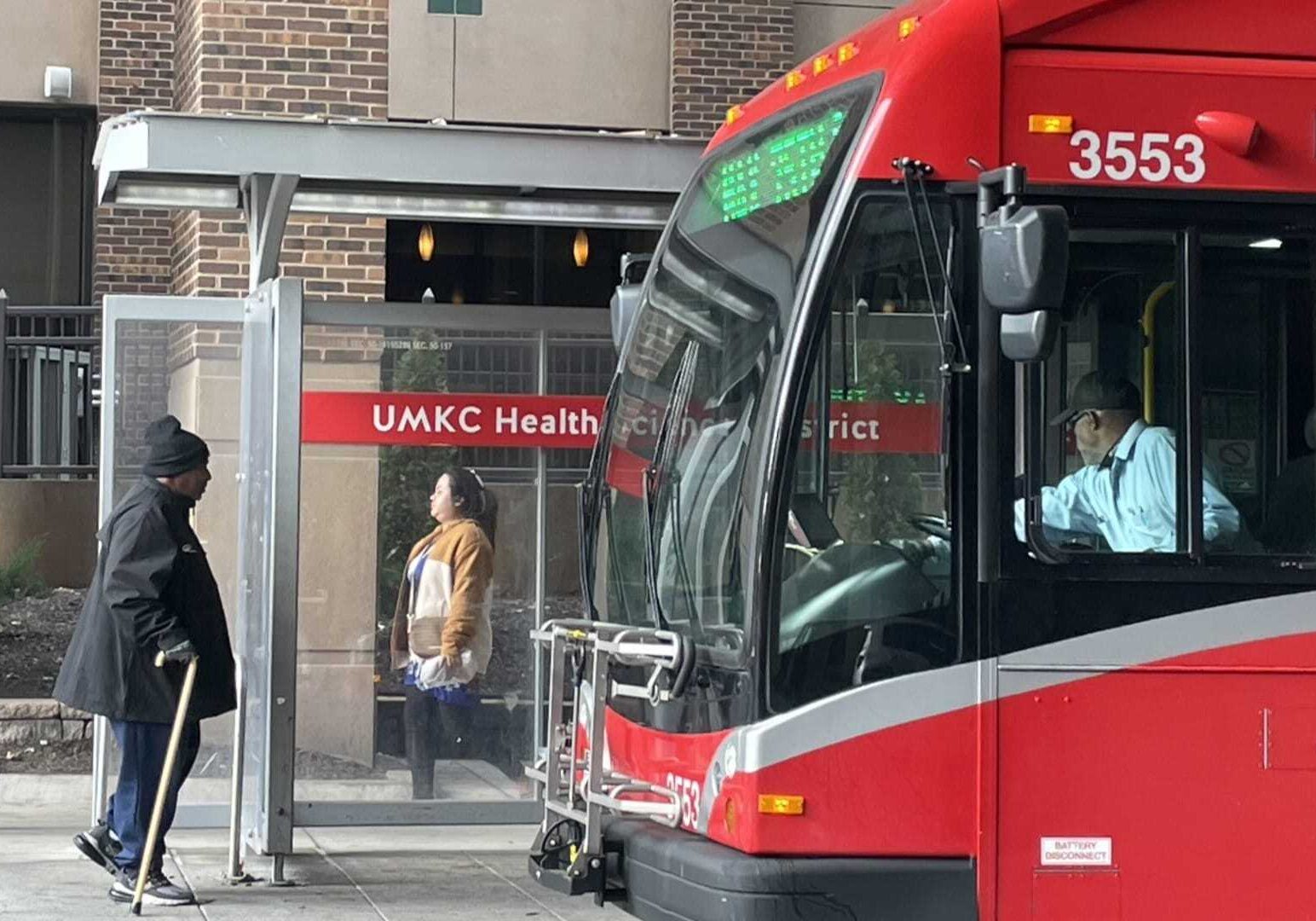 People at a bus stop at University Health.