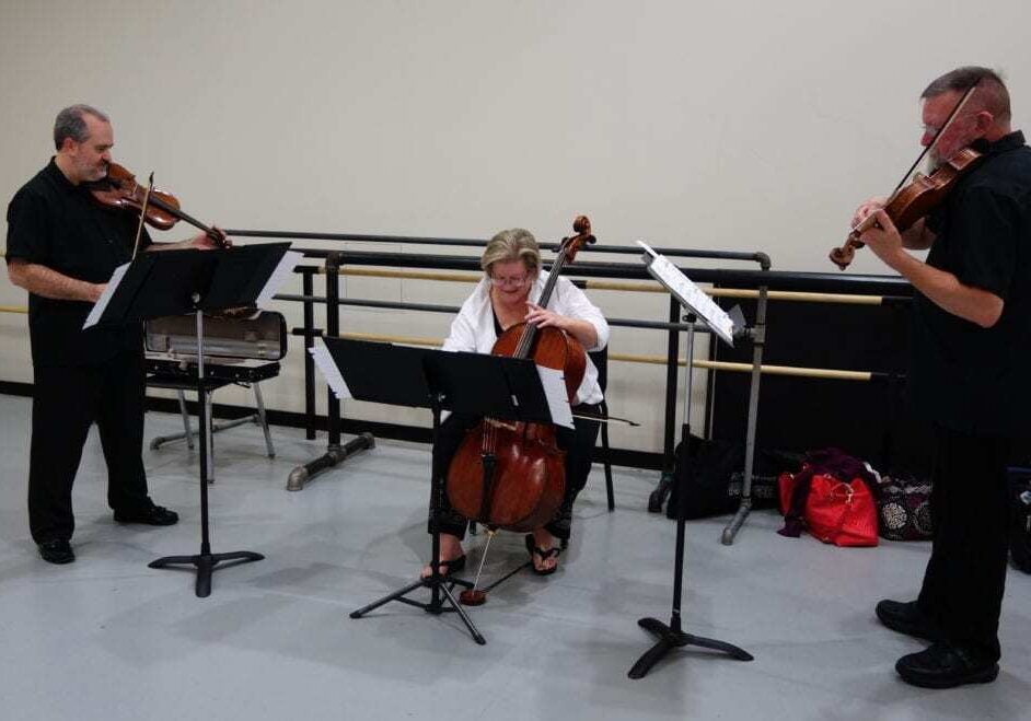 Three people playing string instruments.