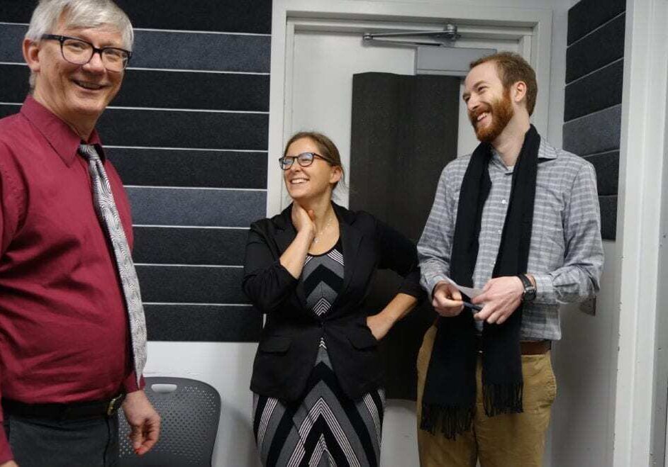 Three individuals laughing together.