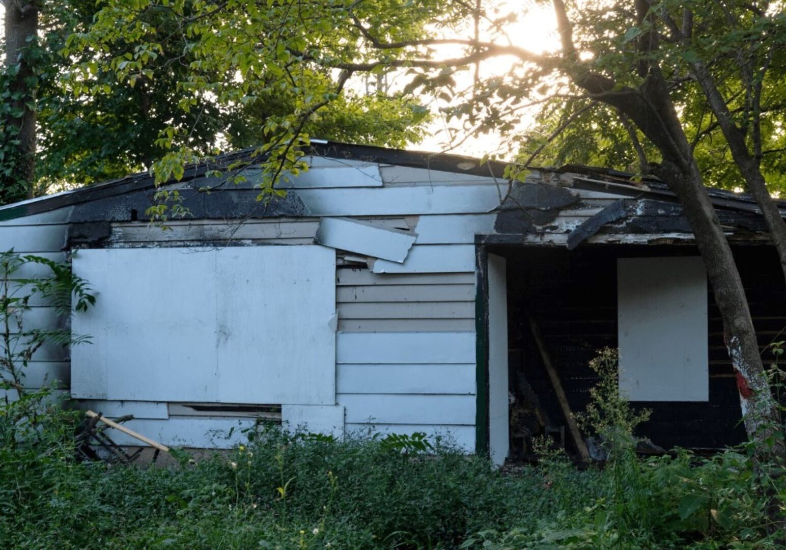 This home on 3329 Spruce Ave. has been on Kansas City's dangerous buildings list since February 2021. The owner of the property is located in Kansas.