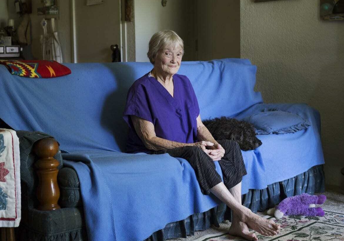 Patricia Corry sitting on her sofa