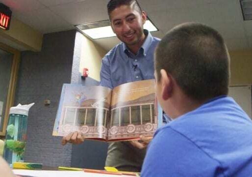 Man showing book to child.